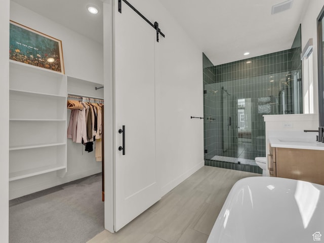 11609 S Dorian Dr W, South Jordan, UT 84009 - full bath featuring a stall shower, a walk in closet, vanity, a freestanding bath, and recessed lighting
