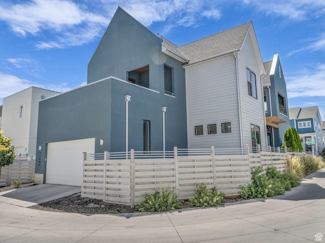 11609 S Dorian Dr W, South Jordan, UT 84009 - view of side of home with an attached garage, concrete driveway, a balcony, and stucco siding
