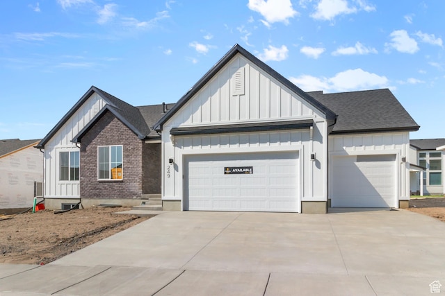 168 N 870 E, Tremonton, UT 84337 - view of front of property featuring board and batten siding, an attached garage, driveway, roof with shingles, and brick siding