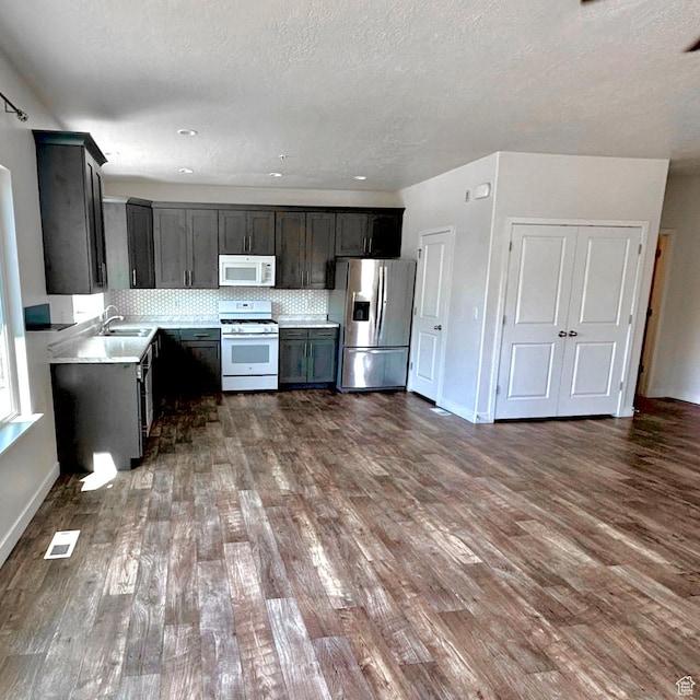 5382 W Tioga Pl, Herriman, UT 84096 - kitchen featuring white appliances, dark wood-style flooring, light countertops, decorative backsplash, and a textured ceiling