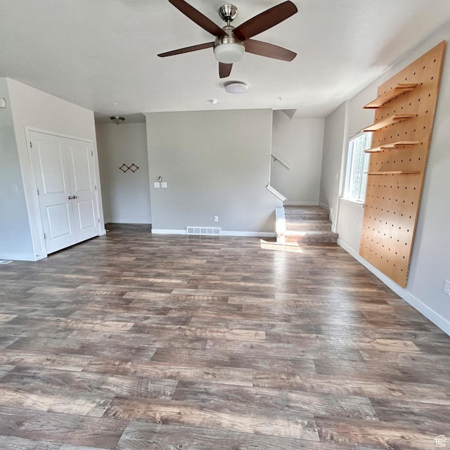 5382 W Tioga Pl, Herriman, UT 84096 - unfurnished living room featuring a ceiling fan, wood finished floors, and stairs