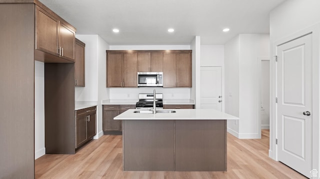 1068 E 1930 S Unit 421, Heber City, UT 84032 - kitchen featuring appliances with stainless steel finishes, light wood-style floors, a center island with sink, light countertops, and recessed lighting