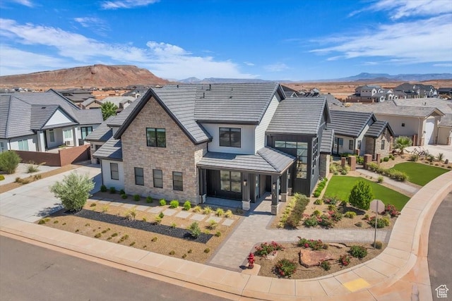 772 E Prairie Way, Washington, UT 84780 - view of front of home featuring stone siding, a mountain view, a residential view, driveway, and a tile roof