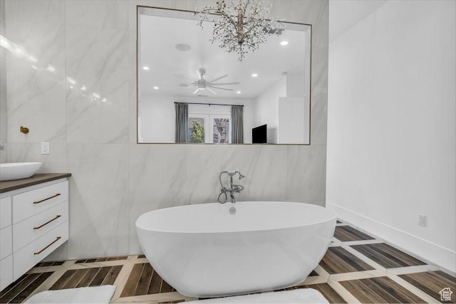 772 E Prairie Way, Washington, UT 84780 - bathroom featuring tile walls, a soaking tub, vanity, recessed lighting, and inlaid floor details
