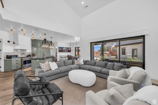 772 E Prairie Way, Washington, UT 84780 - living area featuring light wood-style floors, a chandelier, and high vaulted ceiling