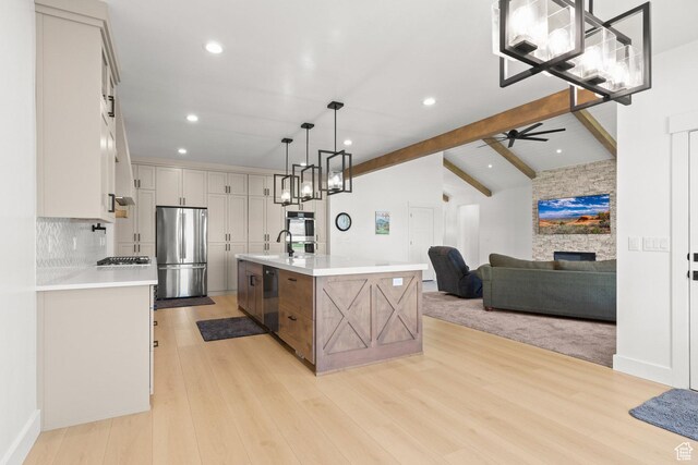 3359 W 3500 S, Wellsville, UT 84339 - kitchen with appliances with stainless steel finishes, a fireplace, light countertops, light wood-style floors, and a ceiling fan
