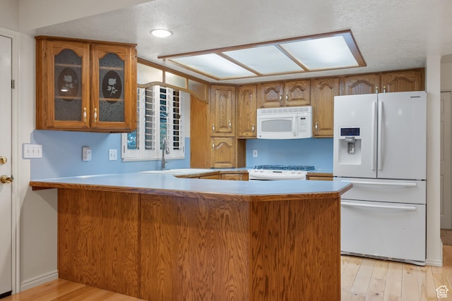 560 S 1350 E, Fruit Heights, UT 84037 - kitchen featuring white appliances, brown cabinetry, glass insert cabinets, a peninsula, and a textured ceiling