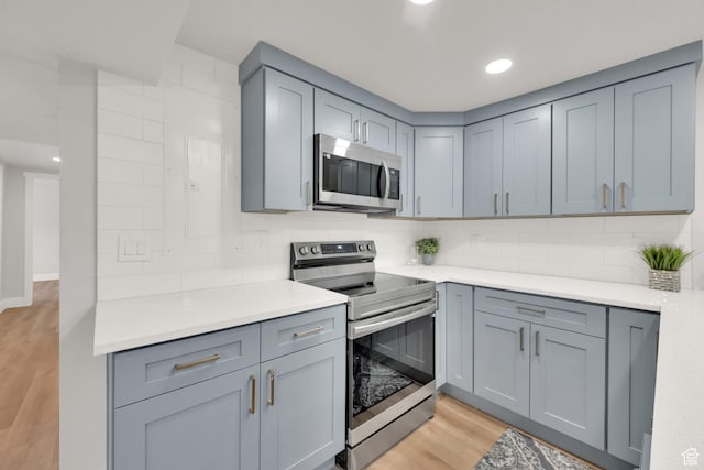 10852 S Starpine Dr, Sandy, UT 84094 - kitchen featuring stainless steel appliances, light wood-type flooring, gray cabinets, decorative backsplash, and light countertops
