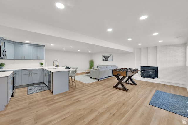 10852 S Starpine Dr, Sandy, UT 84094 - kitchen with open floor plan, appliances with stainless steel finishes, a peninsula, a kitchen breakfast bar, and light countertops
