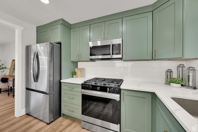 10852 S Starpine Dr, Sandy, UT 84094 - kitchen with stainless steel appliances, green cabinets, light wood-style floors, and backsplash