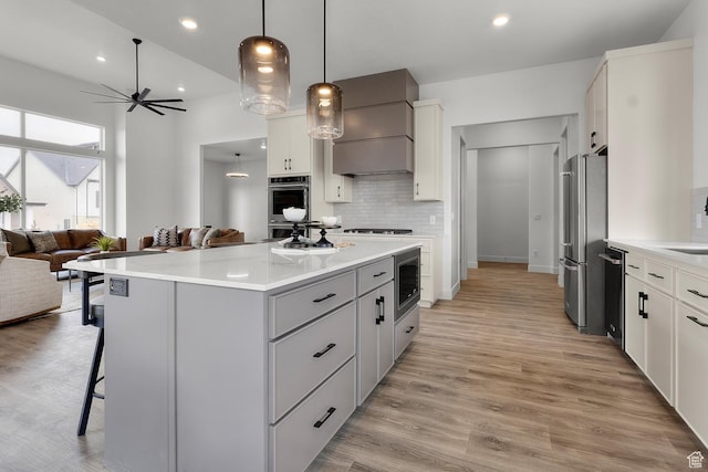 4269 N Maple Hollow Dr Unit 117, Lehi, UT 84043 - kitchen with a breakfast bar area, appliances with stainless steel finishes, open floor plan, ceiling fan, and a center island