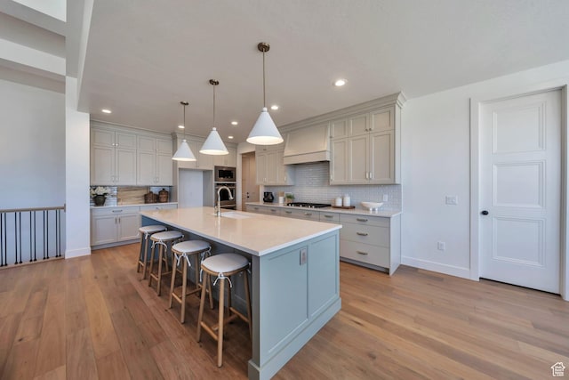 7991 S Ambrosia Ln, West Jordan, UT 84081 - kitchen featuring stainless steel appliances, custom range hood, decorative backsplash, light wood-style flooring, and light countertops