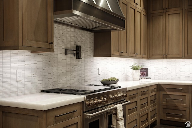 9156 E Forest Rd Unit 24, Heber City, UT 84032 - kitchen featuring high end stainless steel range, wall chimney exhaust hood, tasteful backsplash, and light countertops