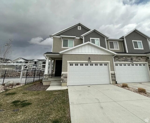 1738 W Terra Vis, Saratoga Springs, UT 84045 - view of front of house featuring stone siding, board and batten siding, driveway, an attached garage, and stucco siding