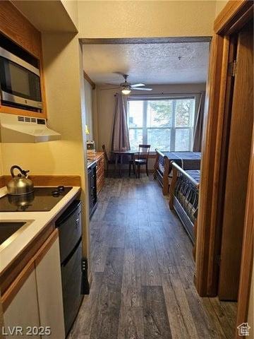 223 Hunter Ridge Rd Unit E121, Brian Head, UT 84719 - kitchen featuring range hood, stainless steel microwave, dark wood-style flooring, ceiling fan, and light countertops