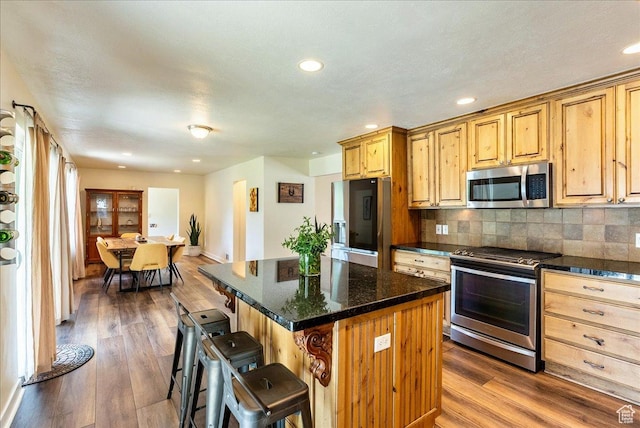 1680 E Fieldcrest Ln, Holladay, UT 84117 - kitchen featuring stainless steel appliances, a breakfast bar area, dark wood finished floors, backsplash, and recessed lighting