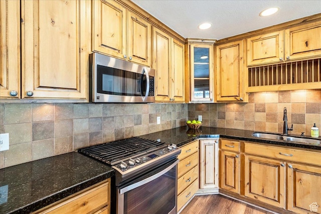 1680 E Fieldcrest Ln, Holladay, UT 84117 - kitchen with appliances with stainless steel finishes, dark stone counters, wood finished floors, decorative backsplash, and glass insert cabinets