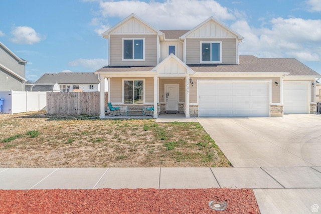 2477 W 2900 N, Farr West, UT 84404 - view of front of house with board and batten siding, covered porch, driveway, stone siding, and an attached garage