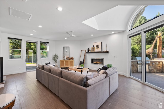 6273 S Oakcrest Cir, Holladay, UT 84121 - living area with plenty of natural light, a glass covered fireplace, recessed lighting, wood finished floors, and a ceiling fan
