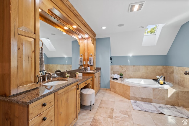 6273 S Oakcrest Cir, Holladay, UT 84121 - bathroom featuring a skylight, a bath, two vanities, tile patterned floors, and recessed lighting