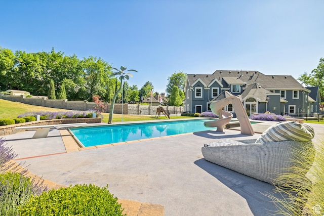 6273 S Oakcrest Cir, Holladay, UT 84121 - view of swimming pool with a patio area, a fenced backyard, a diving board, and a water slide