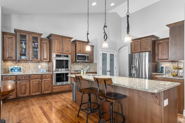 1524 E 330 N, Lehi, UT 84043 - kitchen with stainless steel appliances, high vaulted ceiling, tasteful backsplash, light stone counters, and a breakfast bar area