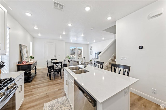 6029 S Carnelian Pkwy, St George, UT 84790 - kitchen featuring appliances with stainless steel finishes, a center island with sink, white cabinets, light countertops, and recessed lighting