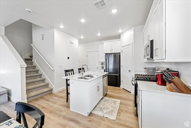 6029 S Carnelian Pkwy, St George, UT 84790 - kitchen featuring appliances with stainless steel finishes, a breakfast bar area, white cabinetry, light wood-style flooring, and recessed lighting