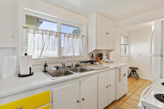 1975 N 2000 W, Farr West, UT 84404 - kitchen with freestanding refrigerator, white cabinets, light tile patterned floors, and plenty of natural light