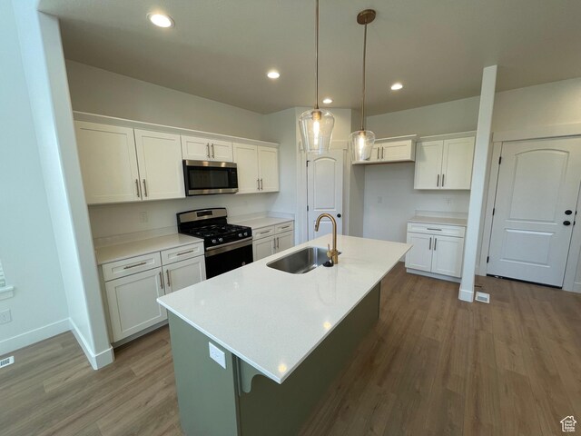 4332 W Watchmen Way, Herriman, UT 84096 - kitchen featuring stainless steel appliances, wood finished floors, white cabinets, an island with sink, and recessed lighting