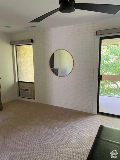 1014 W Bloomington Dr S, St George, UT 84790 - spare room with carpet floors, ceiling fan, brick wall, and a wall mounted air conditioner
