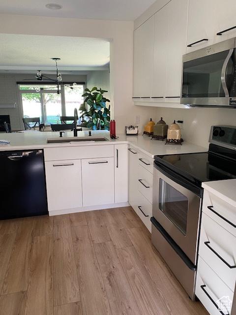 1014 W Bloomington Dr S, St George, UT 84790 - kitchen with appliances with stainless steel finishes, light countertops, white cabinetry, and light wood-style flooring