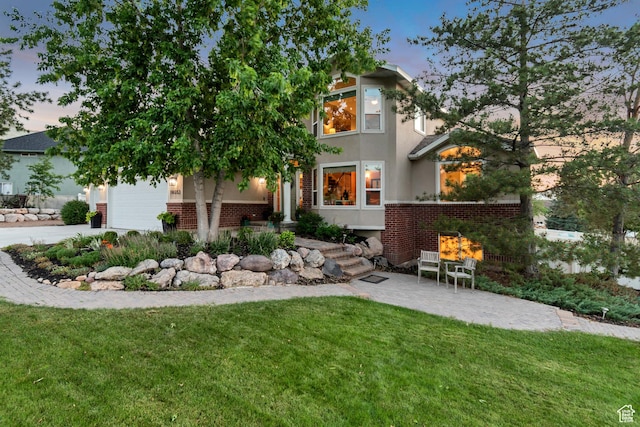 14012 S Osborne Ln E, Draper, UT 84020 - view of front of property with brick siding, a front lawn, stucco siding, a garage, and concrete driveway