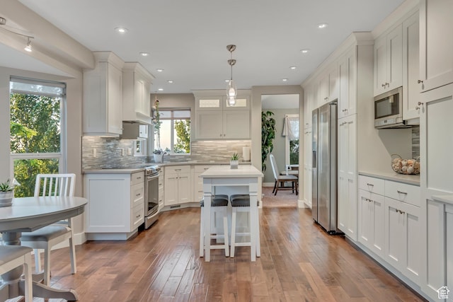 14012 S Osborne Ln E, Draper, UT 84020 - kitchen featuring stainless steel appliances, light countertops, a kitchen island, decorative backsplash, and white cabinets