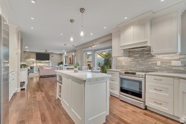 14012 S Osborne Ln E, Draper, UT 84020 - kitchen featuring electric stove, open floor plan, a center island, decorative backsplash, and light countertops