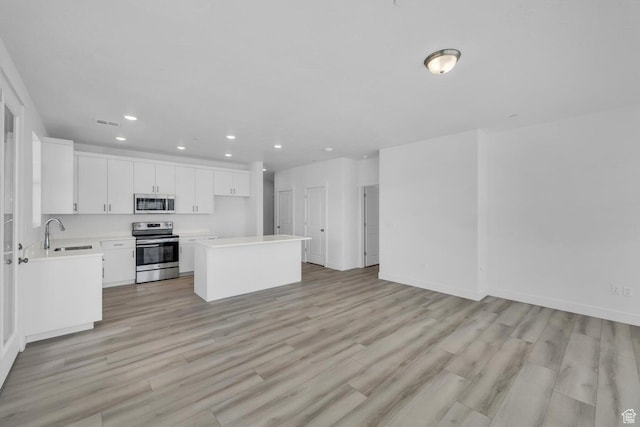 5599 S Carnelian Pkwy Unit 205, St George, UT 84790 - kitchen featuring stainless steel appliances, recessed lighting, light countertops, light wood-style floors, and white cabinetry