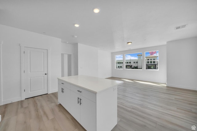 5599 S Carnelian Pkwy Unit 205, St George, UT 84790 - kitchen with light wood finished floors, a kitchen island, white cabinetry, recessed lighting, and light countertops