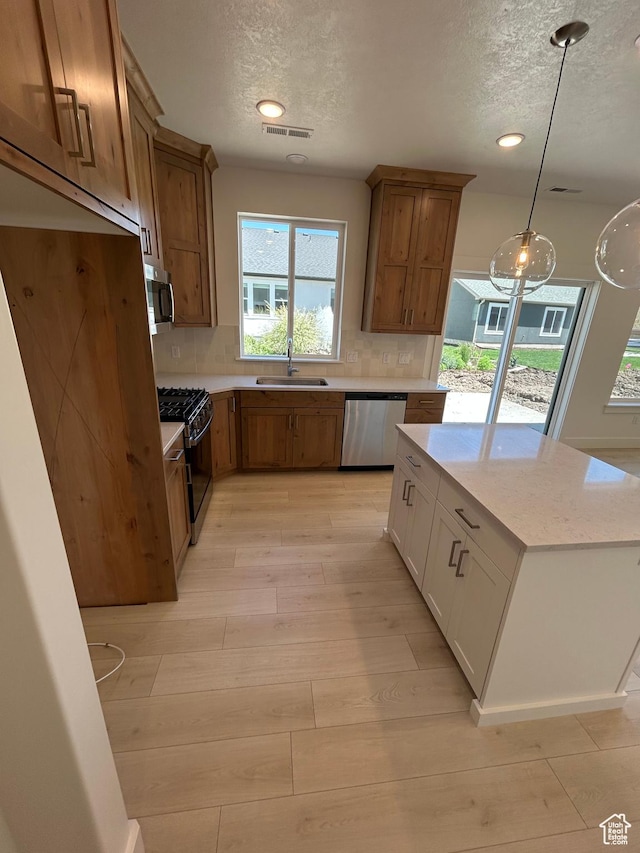 564 N 800 W, Smithfield, UT 84335 - kitchen featuring stainless steel appliances, a textured ceiling, light wood finished floors, brown cabinetry, and tasteful backsplash