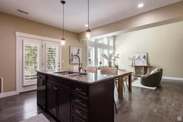 7902 S Farm House Ln E, Midvale, UT 84047 - kitchen with black dishwasher, dark stone countertops, dark wood-style floors, pendant lighting, and a breakfast bar area