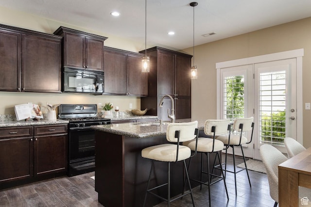 7902 S Farm House Ln E, Midvale, UT 84047 - kitchen featuring black appliances, dark wood-type flooring, a breakfast bar, a kitchen island with sink, and light stone countertops