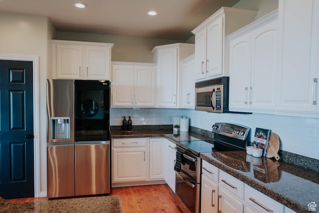 1628 E Lone Oak Dr, Draper, UT 84020 - kitchen with appliances with stainless steel finishes, white cabinets, tasteful backsplash, dark stone countertops, and recessed lighting