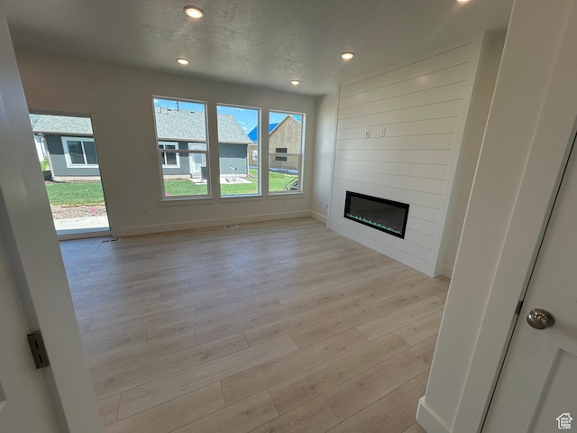 556 N 800 W, Smithfield, UT 84335 - unfurnished living room featuring healthy amount of natural light, light wood-style flooring, a fireplace, and recessed lighting