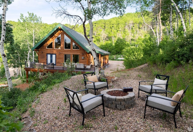2143 S Aspen Cir, Wanship, UT 84017 - back of property featuring a fire pit, a wooden deck, log siding, and a view of trees