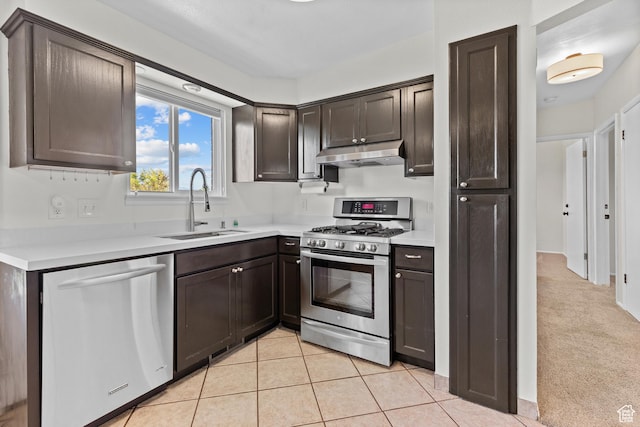 2124 W 7125 S, West Jordan, UT 84084 - kitchen with appliances with stainless steel finishes, under cabinet range hood, dark brown cabinetry, light countertops, and light tile patterned floors