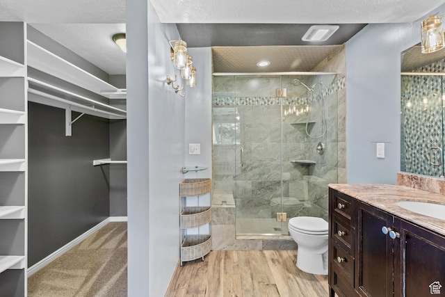 2124 W 7125 S, West Jordan, UT 84084 - bathroom with a walk in closet, vanity, a stall shower, and wood finished floors