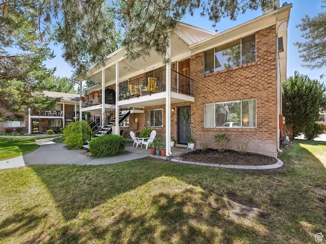 4742 S 700 E Unit 84, Salt Lake City, UT 84107 - rear view of house with brick siding, a balcony, and a yard