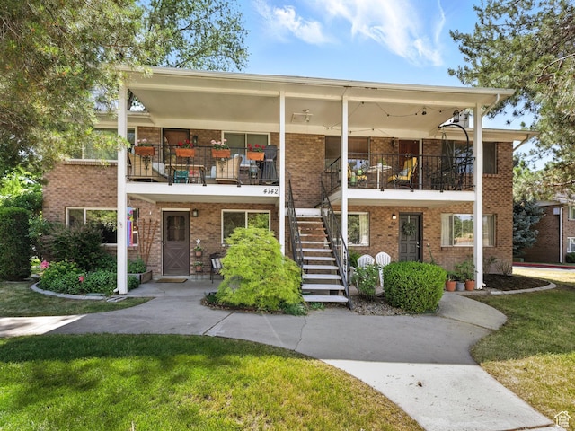 4742 S 700 E Unit 84, Salt Lake City, UT 84107 - view of front of home with brick siding, stairway, and a front lawn