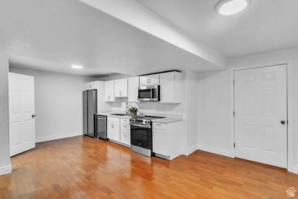1342 S 1340 E, Spanish Fork, UT 84660 - kitchen with stainless steel appliances, white cabinetry, light wood-type flooring, and light countertops