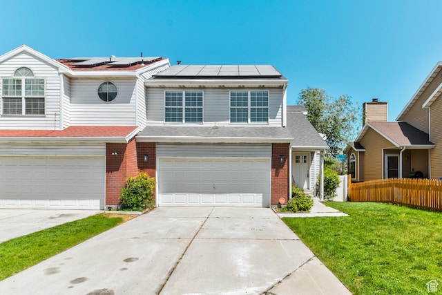 415 E Acoma Rd S, Midvale, UT 84047 - view of front of property with concrete driveway, an attached garage, brick siding, and solar panels