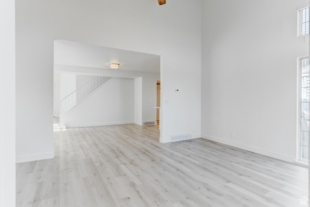 415 E Acoma Rd S, Midvale, UT 84047 - unfurnished room featuring light wood finished floors, stairway, and a towering ceiling